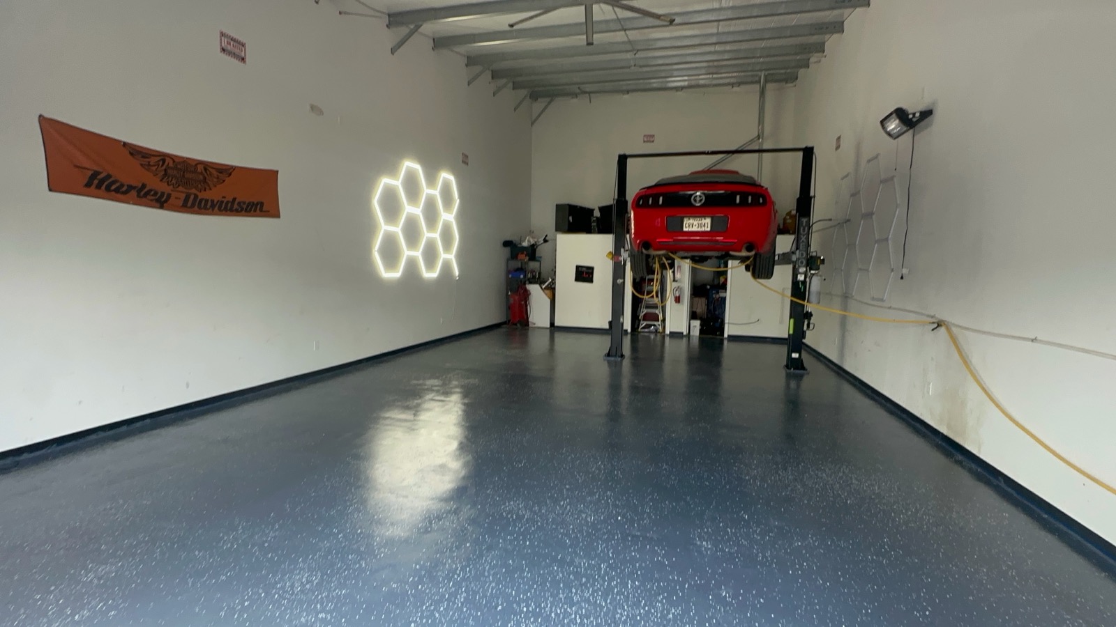 Commercial shop with a durable flake epoxy floor and car lift